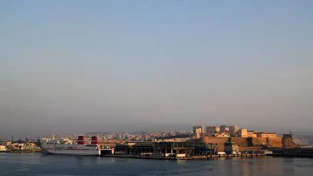 El puerto de Melilla y su frente marítimo vistos desde el mar, con la ciudad vieja recortada al fondo.
